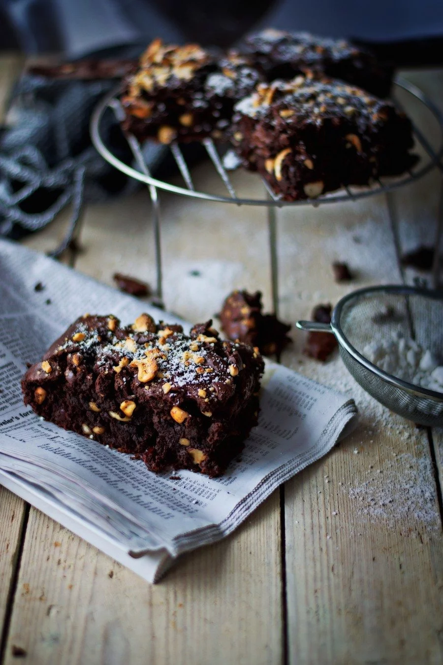 Another closeup to the Salted-Cashew Orange-Cranberry Brownies, on a newspaper.