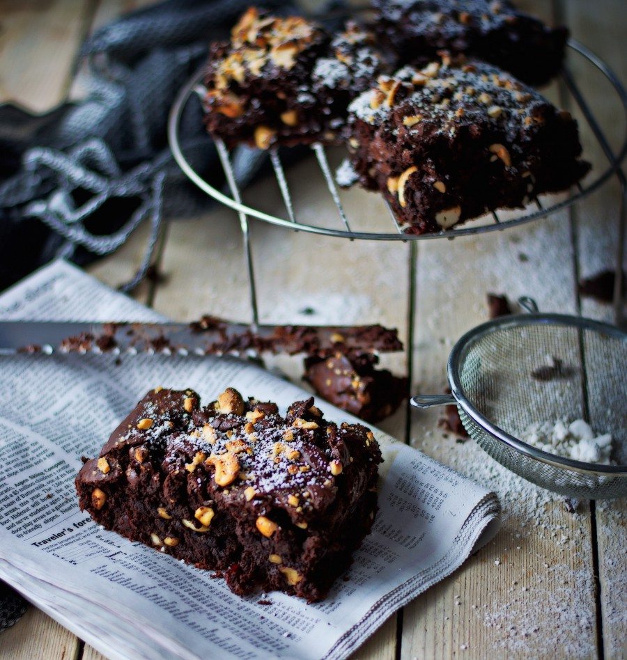 A piece of the Salted-Cashew Orange-Cranberry Brownies in the foreground with more in the background.