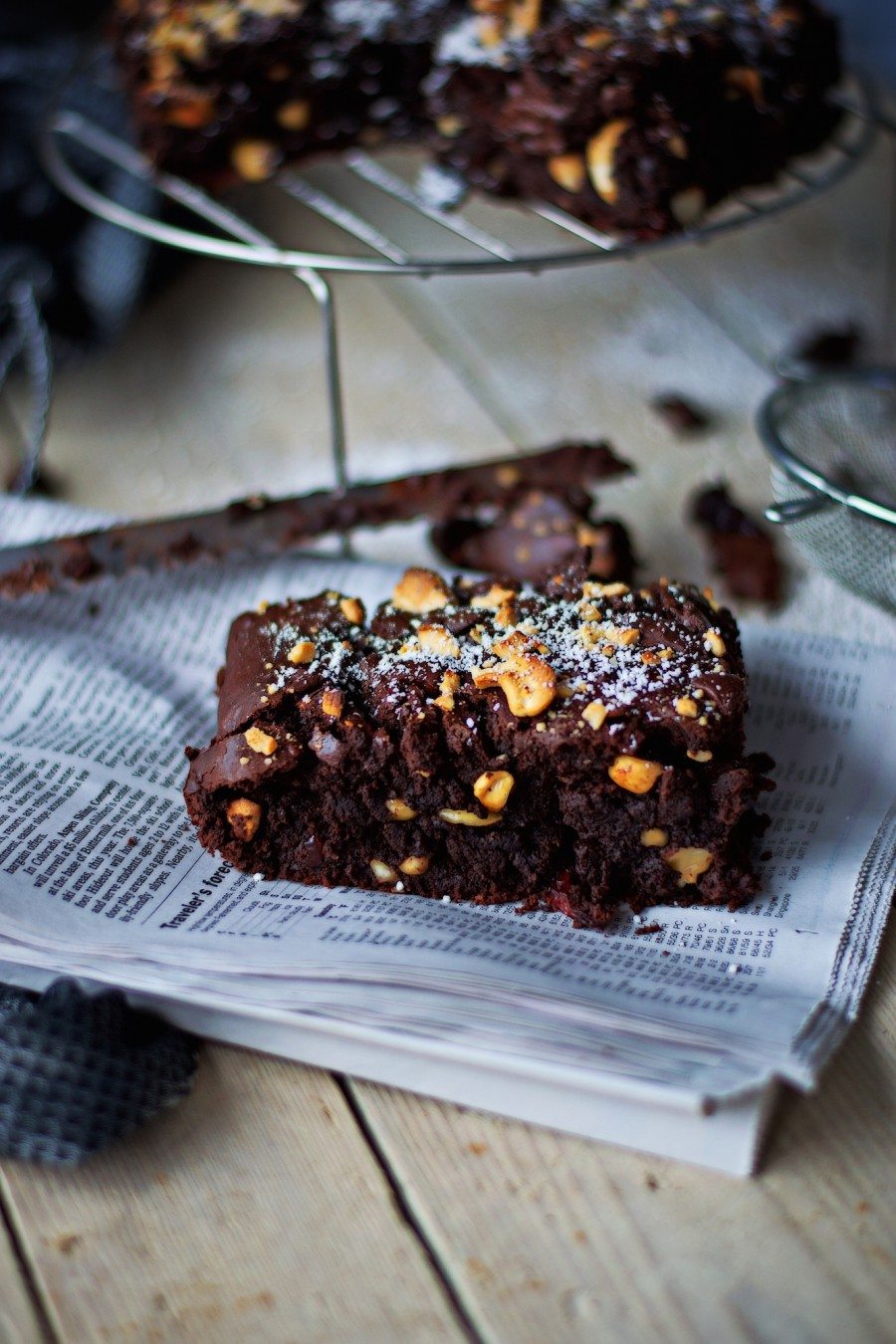 A slice of Salted-Cashew Orange-Cranberry Brownies covered in powdered sugar.