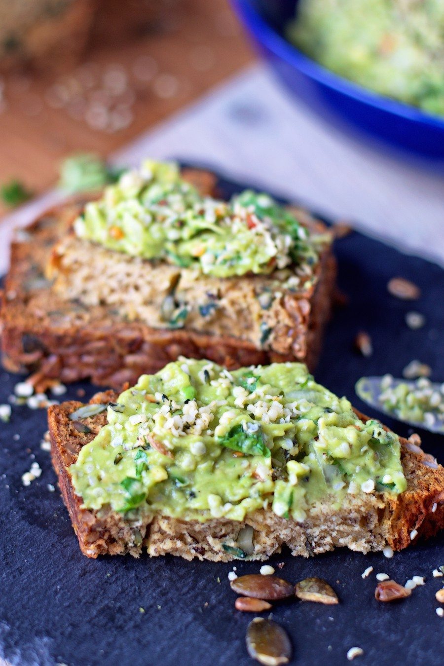 A slice of the Pumpkin & Sunflower Seed Ryebread with Hemp Guacamole in a side view.