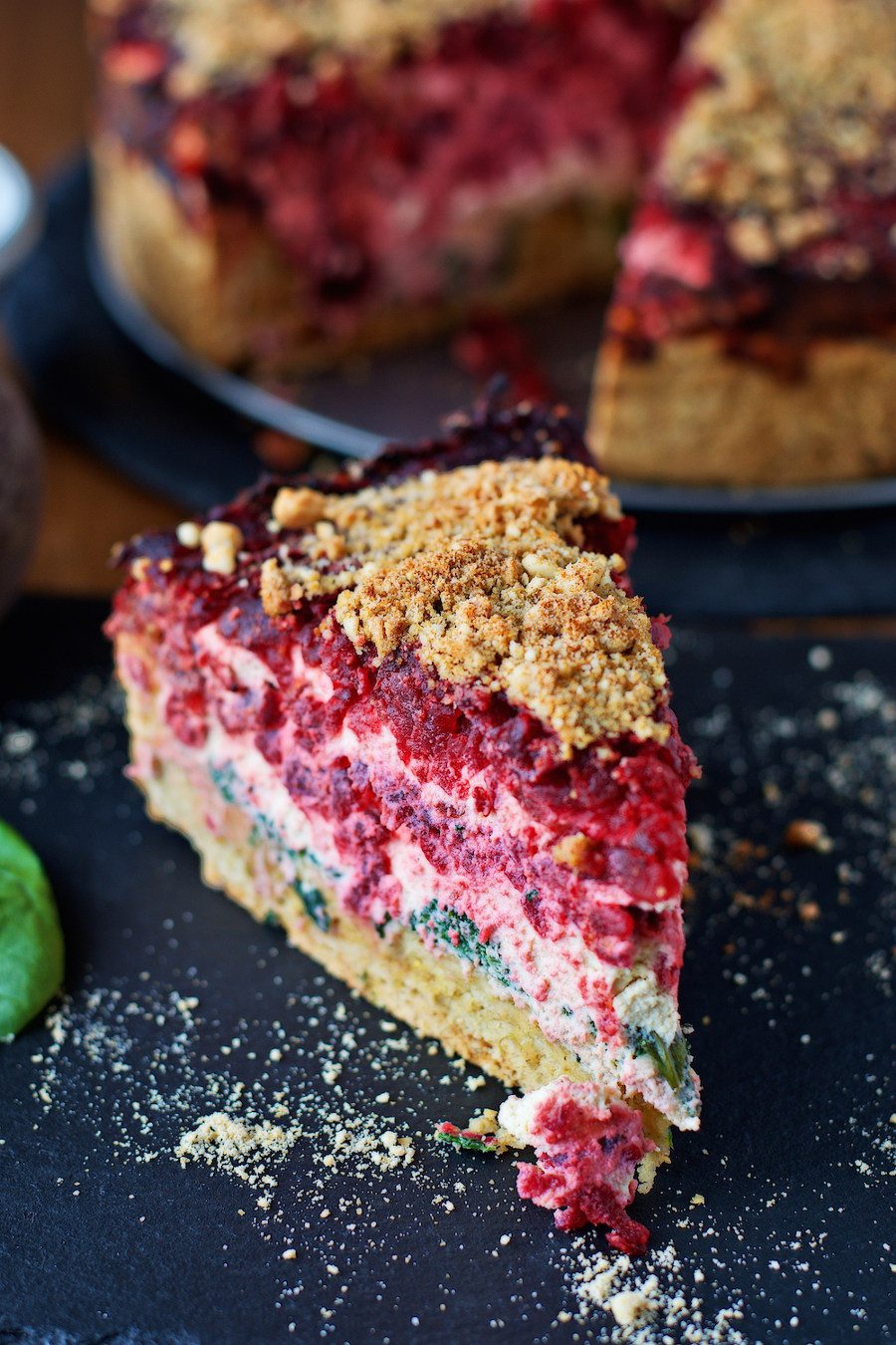 One large piece of the Beet and Spinach Tart taken out, on a serving plate.