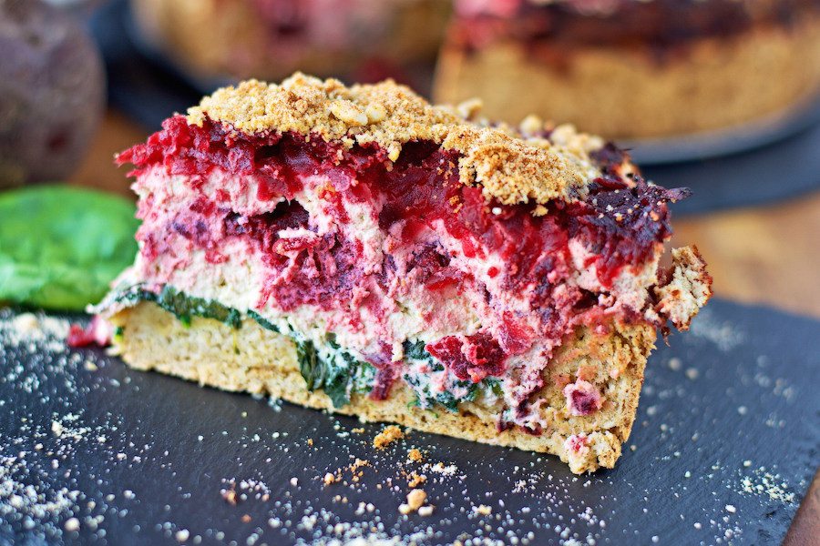 Side view on a slice of Beet and Spinach Tart showing the different layers inside.