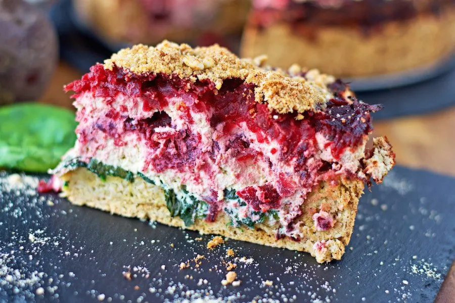 Side view on a slice of Beet and Spinach Tart showing the different layers inside.