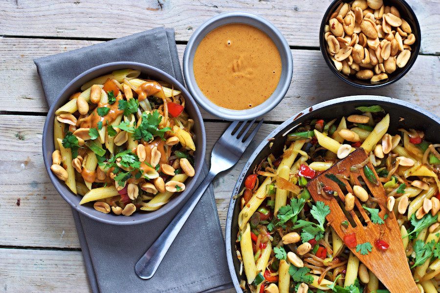 Top view of a Creamy Peanut Pasta in a small bowl and a saucepan.