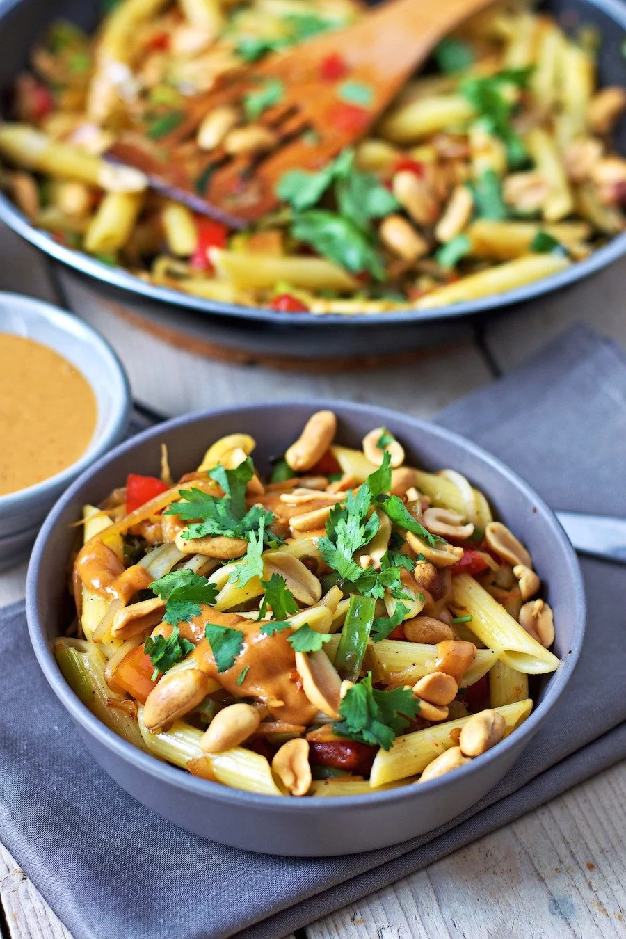 Closeup showing the creamy peanut sauce topping the pasta bowl.