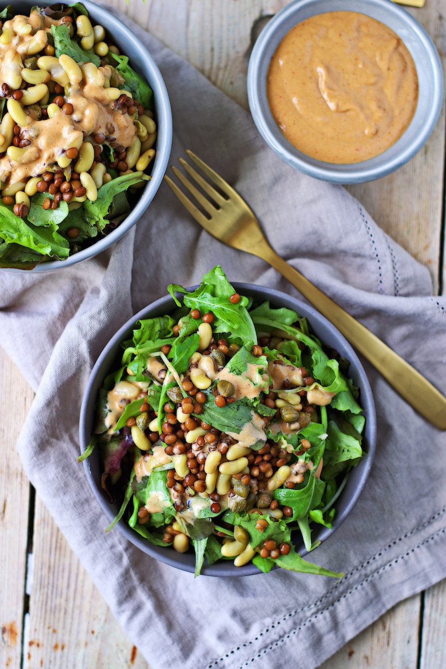 Two bowls of the high Protein Salad with a small bowl of dressing on the side.