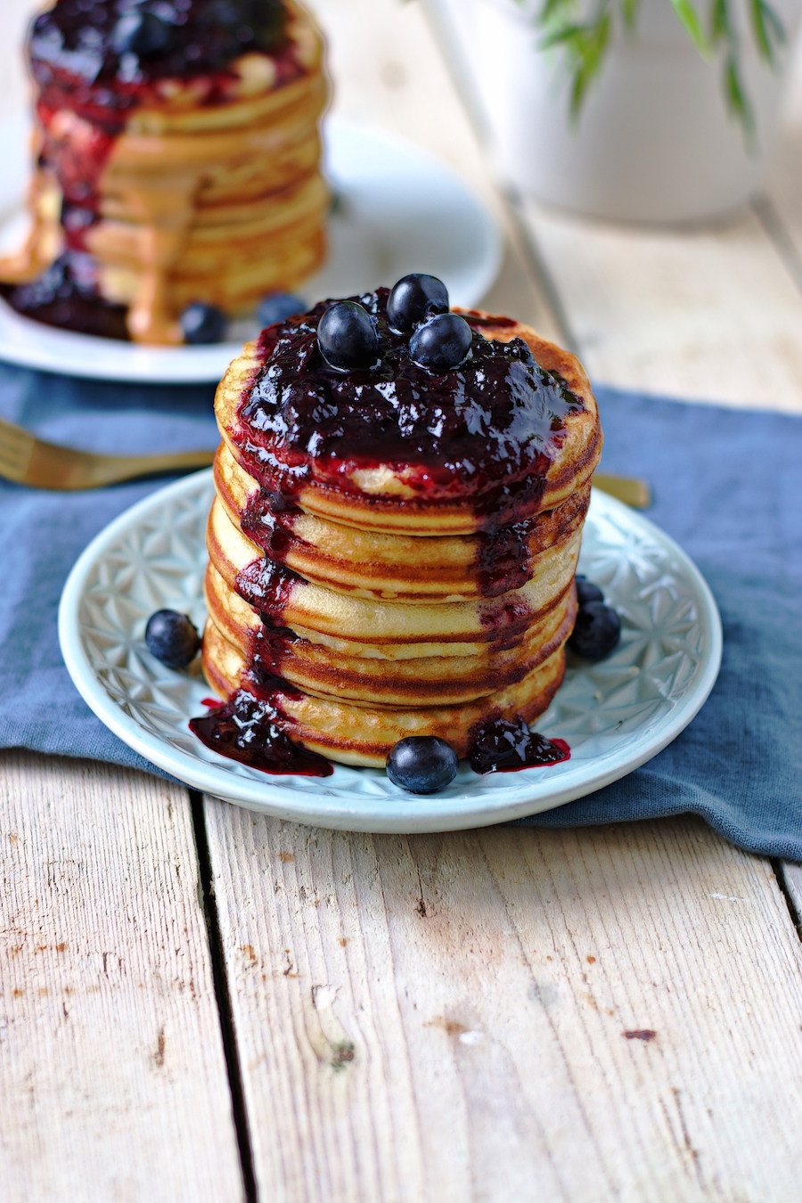 Stack of Vegan Pancakes on a plate, covered with blueberry sauce. #vegan #glutenfree www.contentednesscooking.com