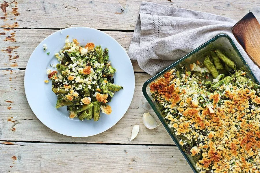 Top view of the kale pasta casserole on a plate and in the casserole dish.