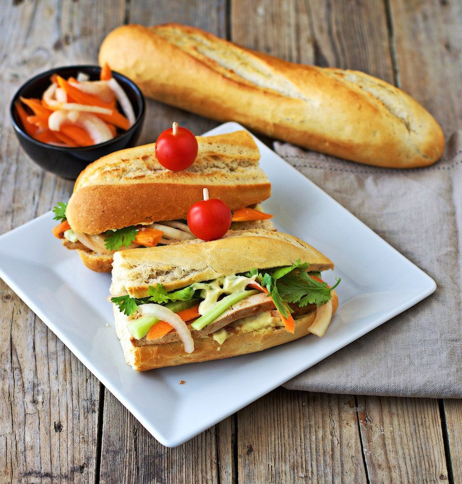 Two Vegan Banh Mi sandwiches on a white plate.