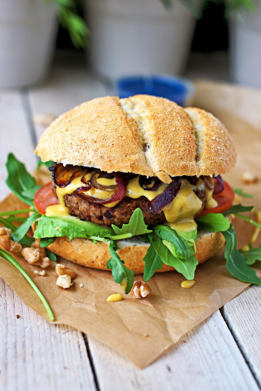 Side view on the Vegan Lentil Burger with the lentil patty and the mustard sauce dripping put.