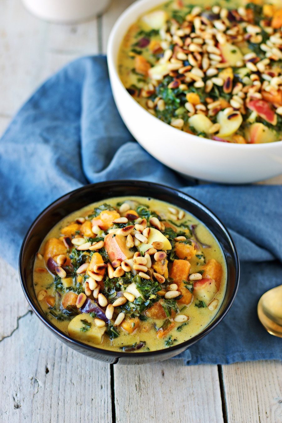 Closeup of a portion of the Vegan Sweet Potato Soup with Kale in a black bowl.