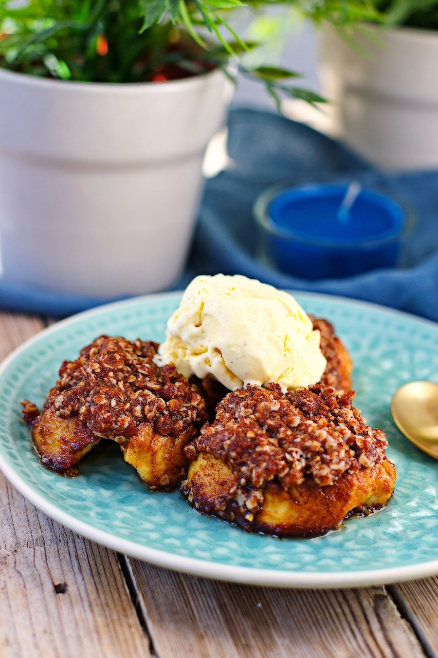 Side view on the three baked apples, topped with a dollop of ice cream.