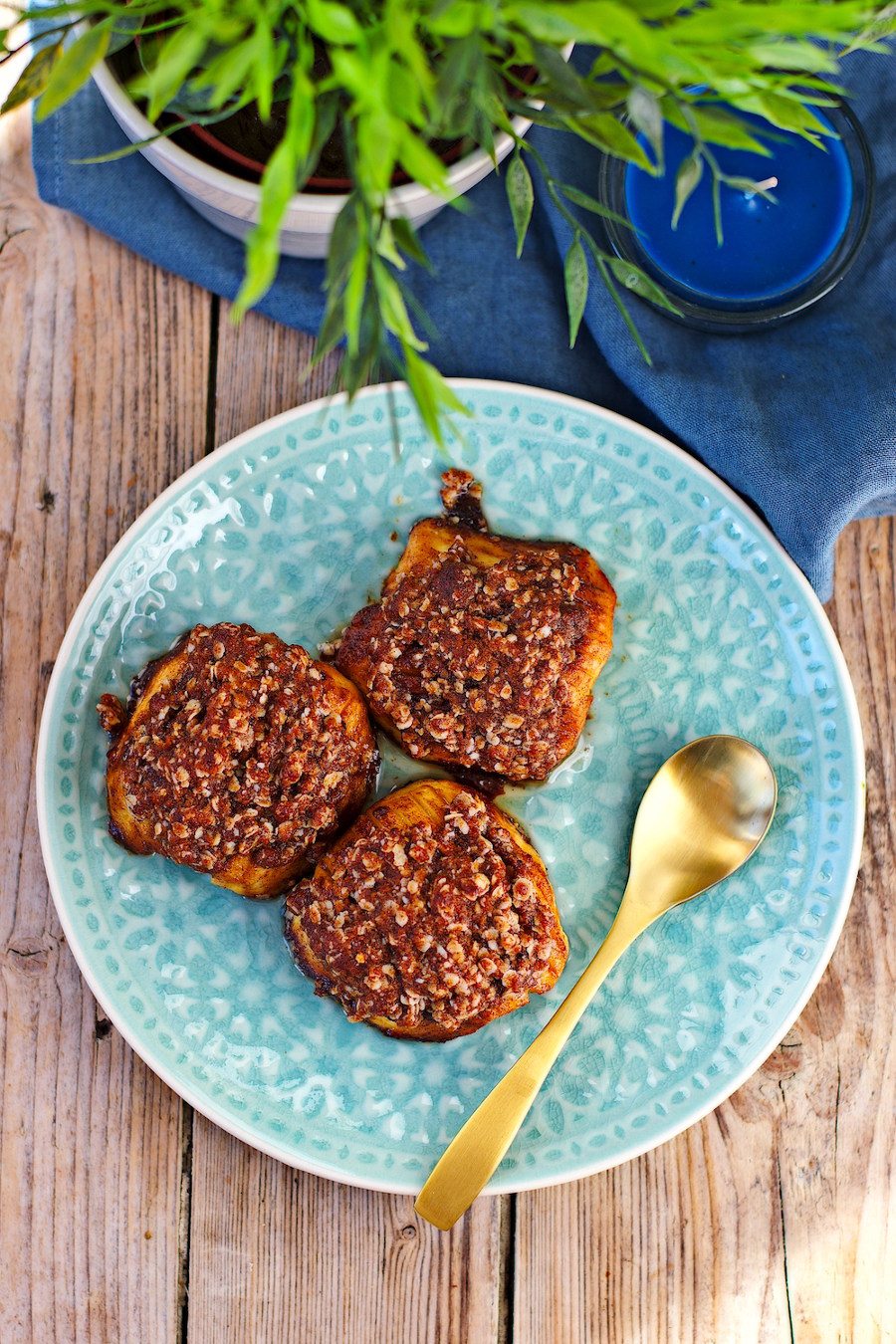 Top view on three Baked Apples on a blue plate with golden cutlery.