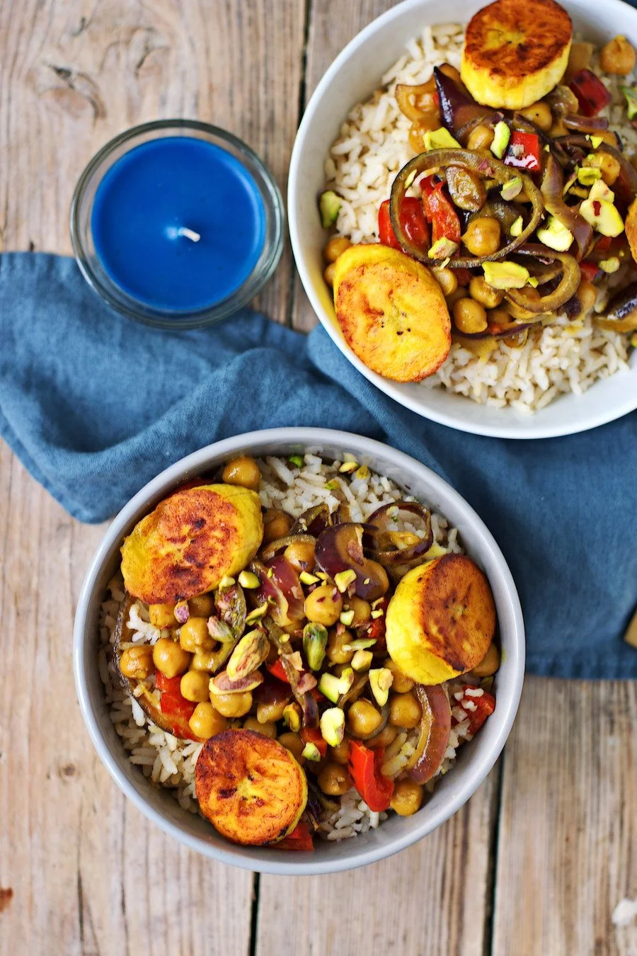 Top view on a bowl of Vegetable Curry with Plantains showing rice, chickpeas, pistachios, and plantains.