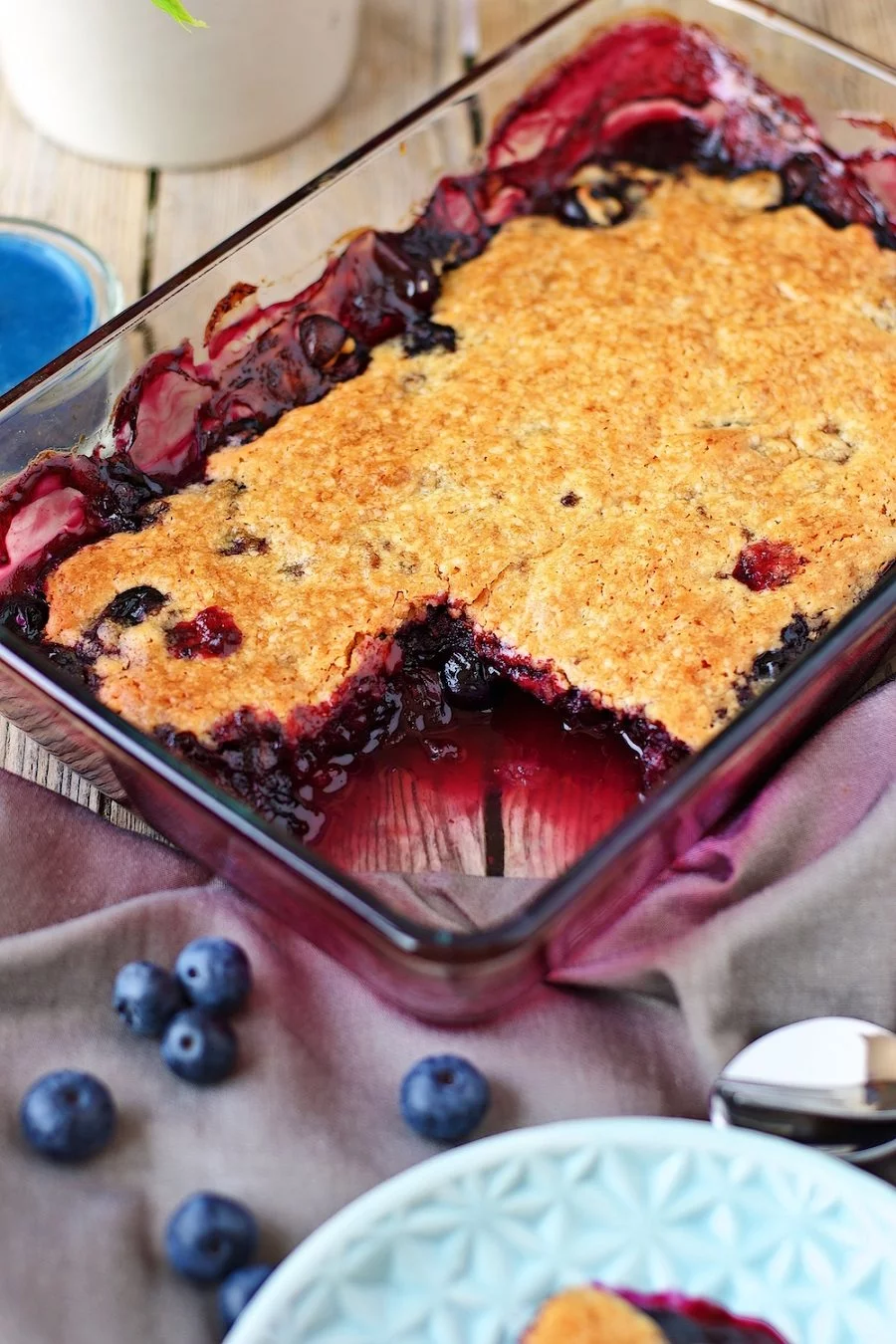 Closeup on the Easy Blueberry Cobbler in the casserole dish, showing the juicy fruit mix and crunchy top.