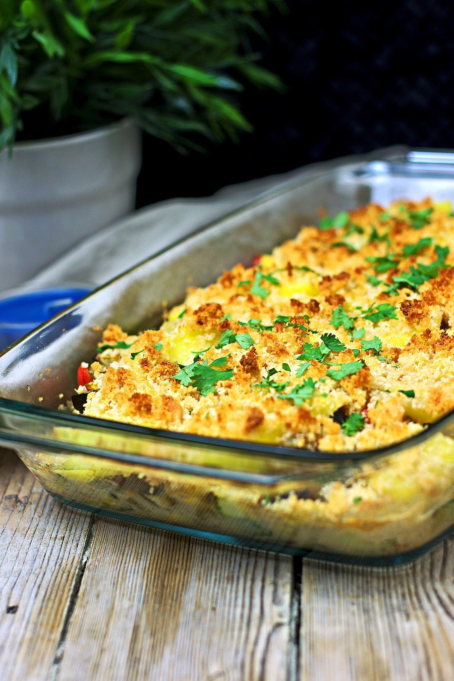 Golden baked Vegan Potato Casserole in a glass casserole.