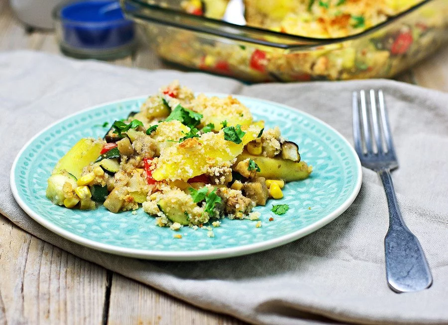 Plate with Vegan Potato Casserole on a grey towel with a silver spoon.