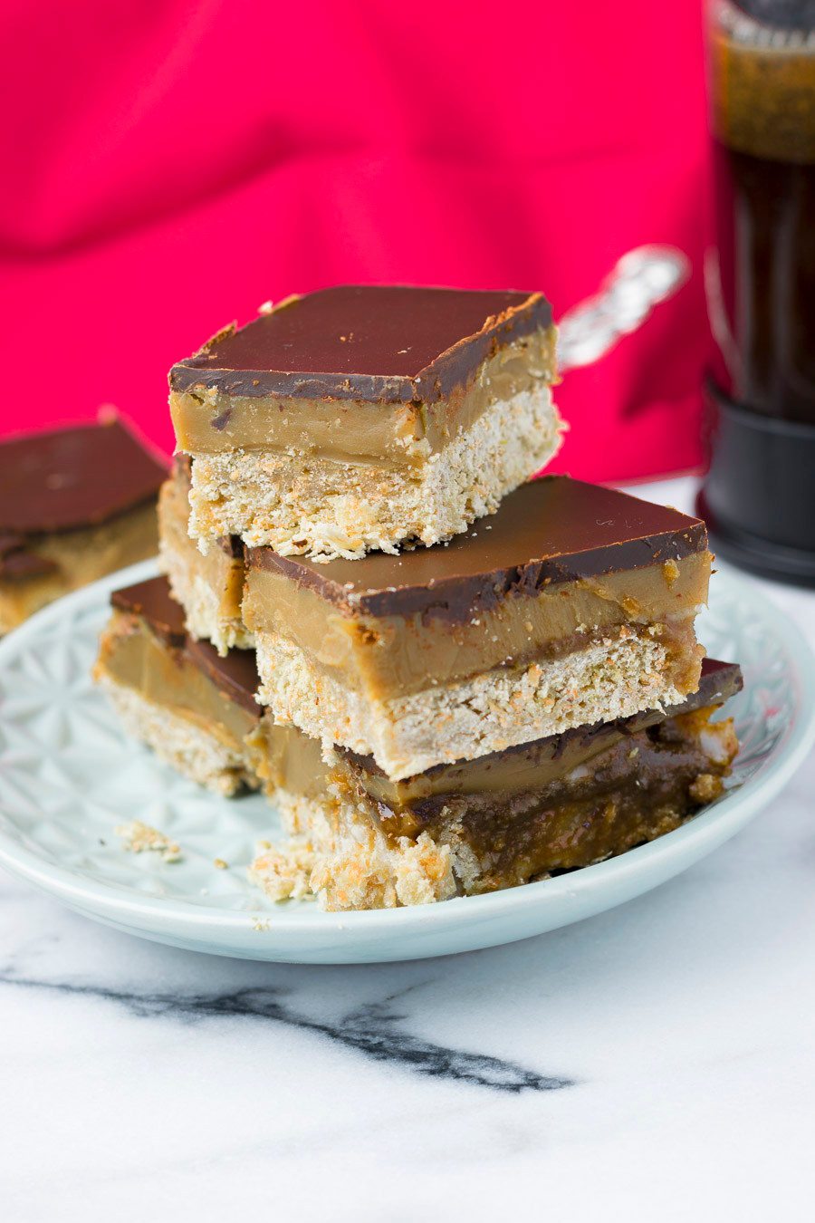 A stack of several pieces of the Vegan Caramel Shortbread on a light blue plate.