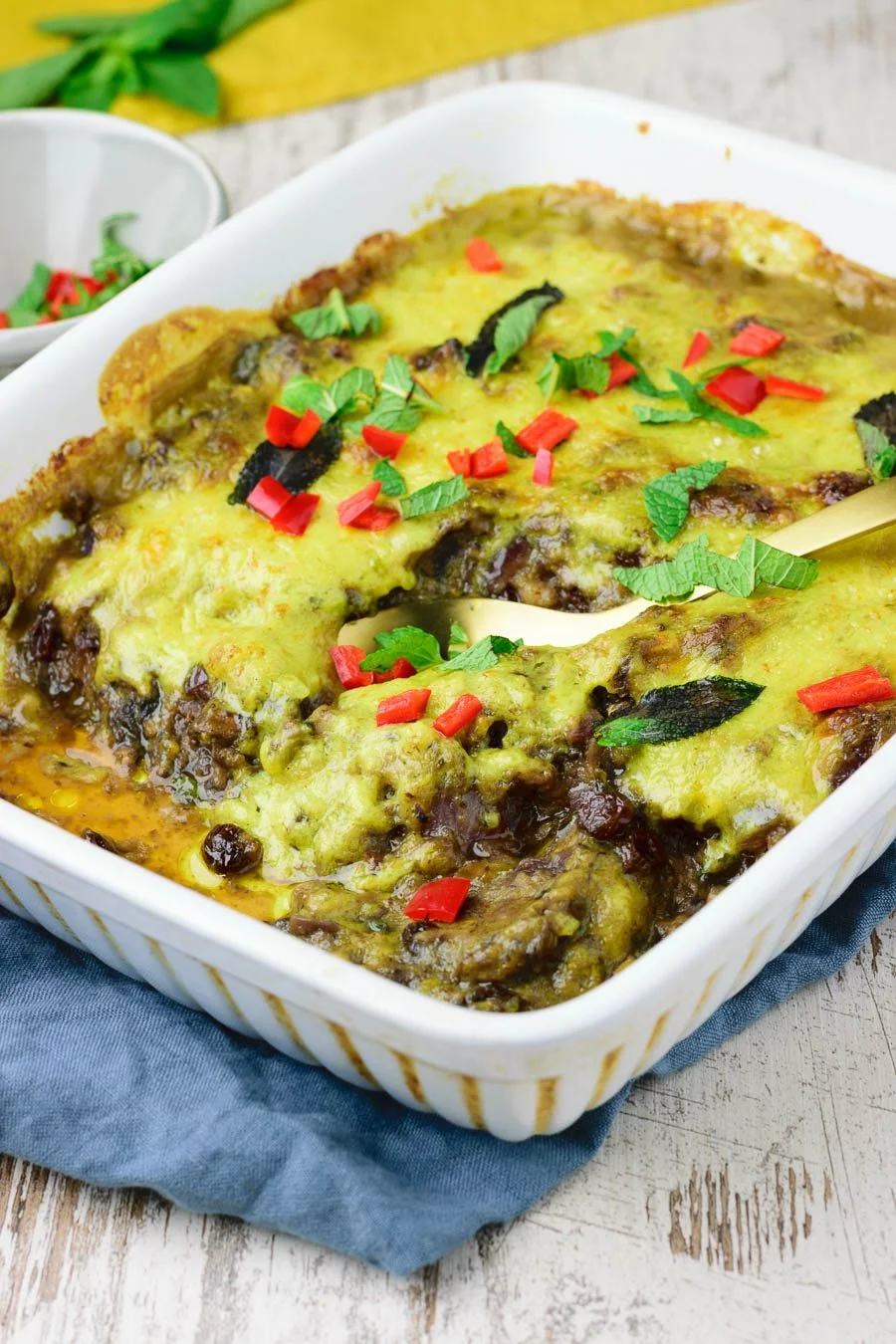 View of the Vegan Bobotie in the casserole dish, with a golden spoon.