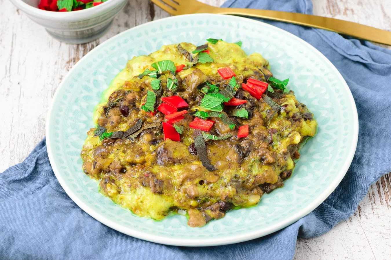 Closeup view of the Vegan Bobotie garnished with mint and chili.