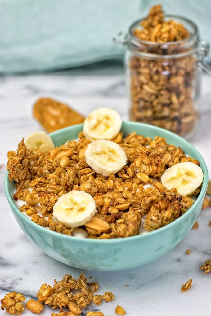 Top view on a breakfast bowl Homemade PB&J Granola and extra granola in a small jar.