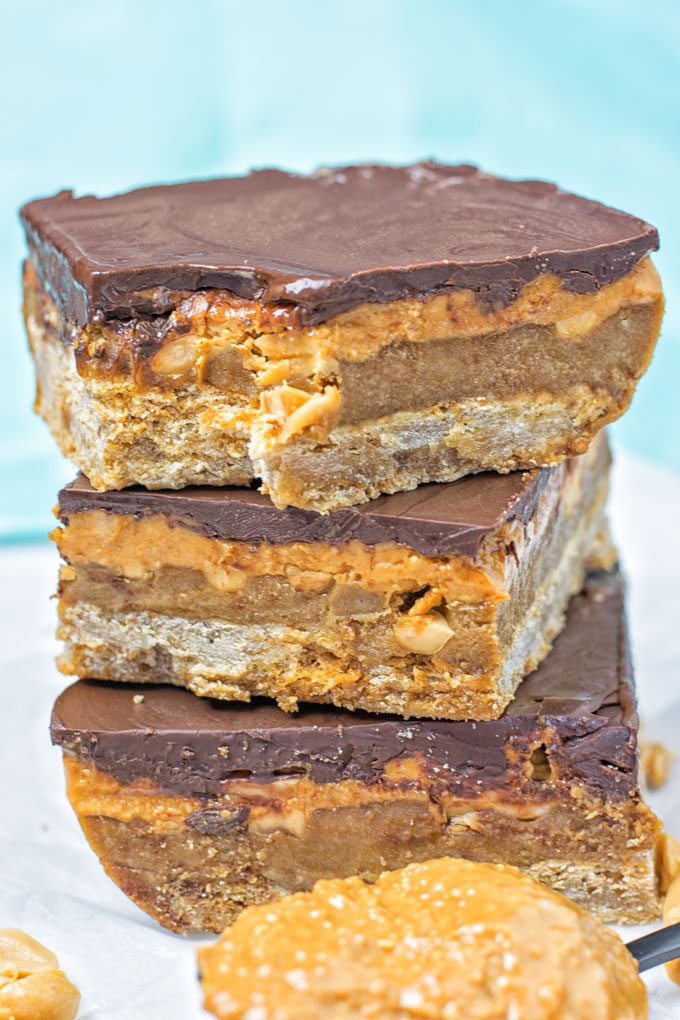Vegan Snickers Bars with a bite taken out of one.