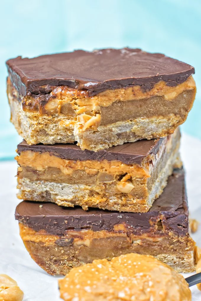 Vegan Snickers Bars with a bite taken out of one.