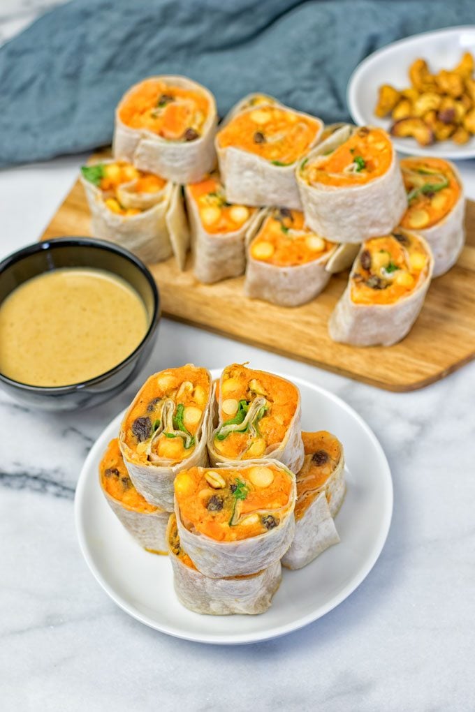 Stacks of the Thai Green Curry Samosa Pinwheels on a plate and wooden board.