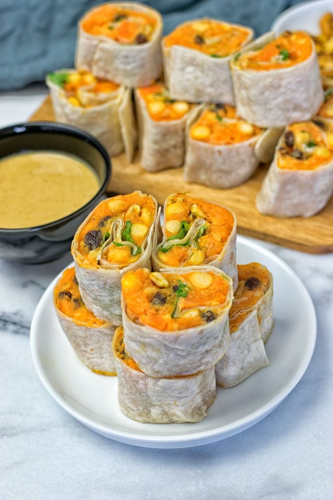 Closeup on a stack of Thai Green Curry Samosa Pinwheels on a plate.