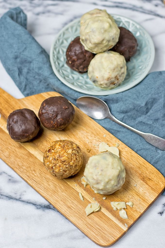 Servings of the Chocolate Ganache Energy Balls on a board and on a plate.