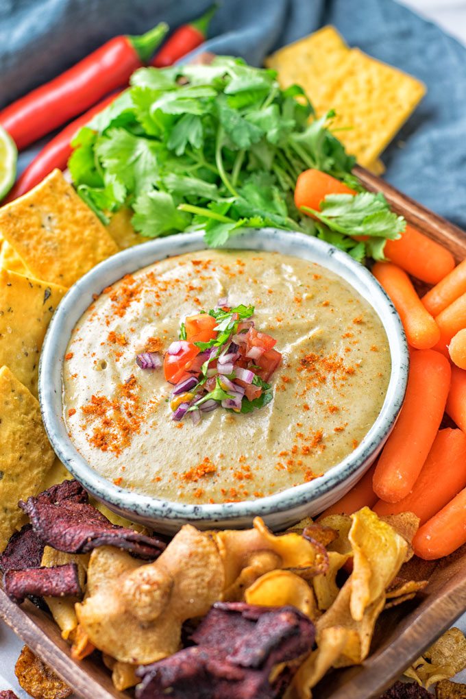 Bowl of the Mexican Cheese Dip served with fresh vegetables and veggie chips.