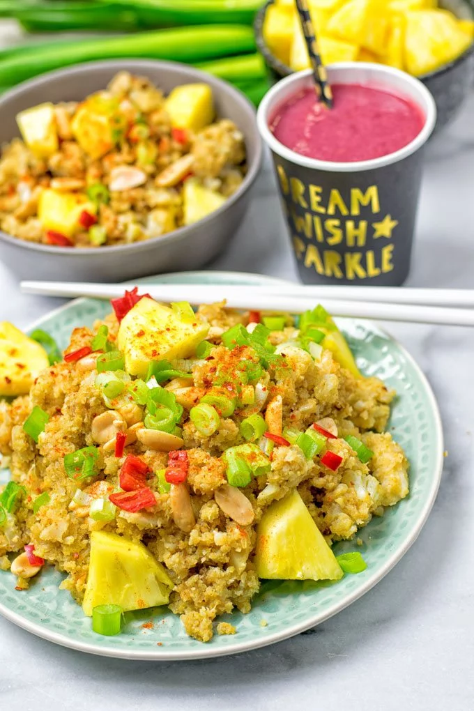 Closeup on a plate of Thai Green Curry Detox Cauliflower Rice with white chopsticks.