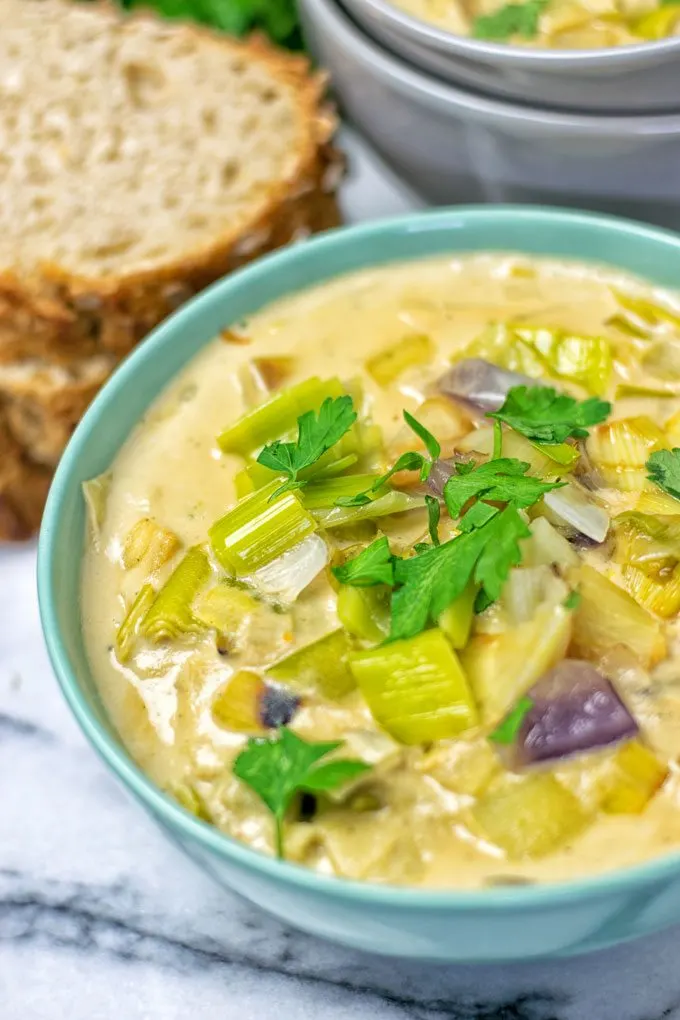 Topping the Vegan Cheese Leek Soup with fresh herbs.