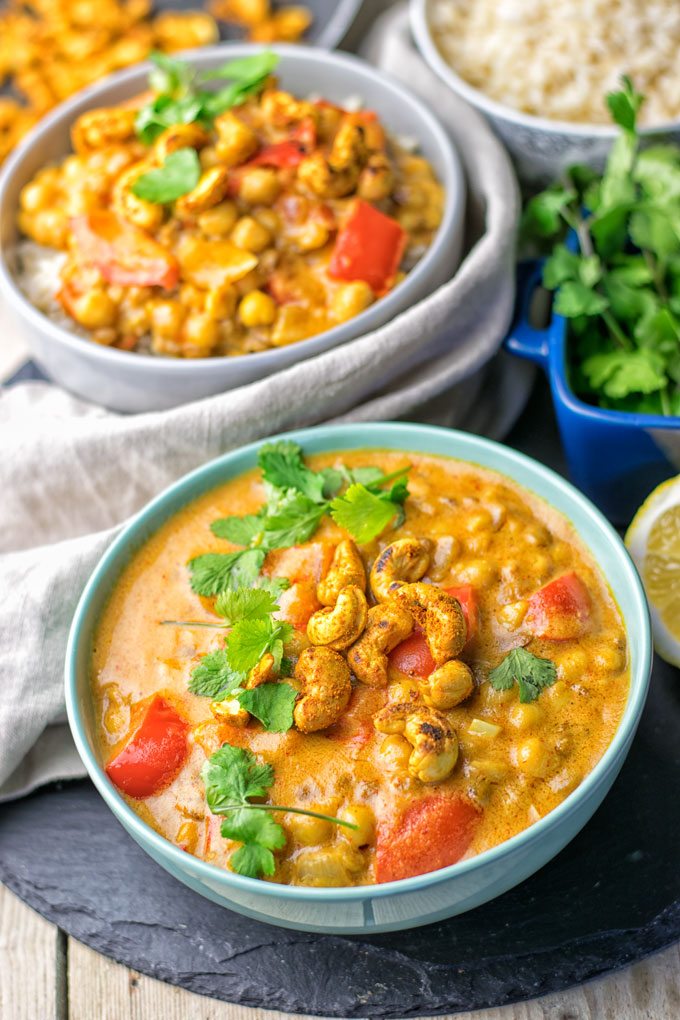 Two bowls of the Lentil Chickpea Yellow Curry with a decorative towel.