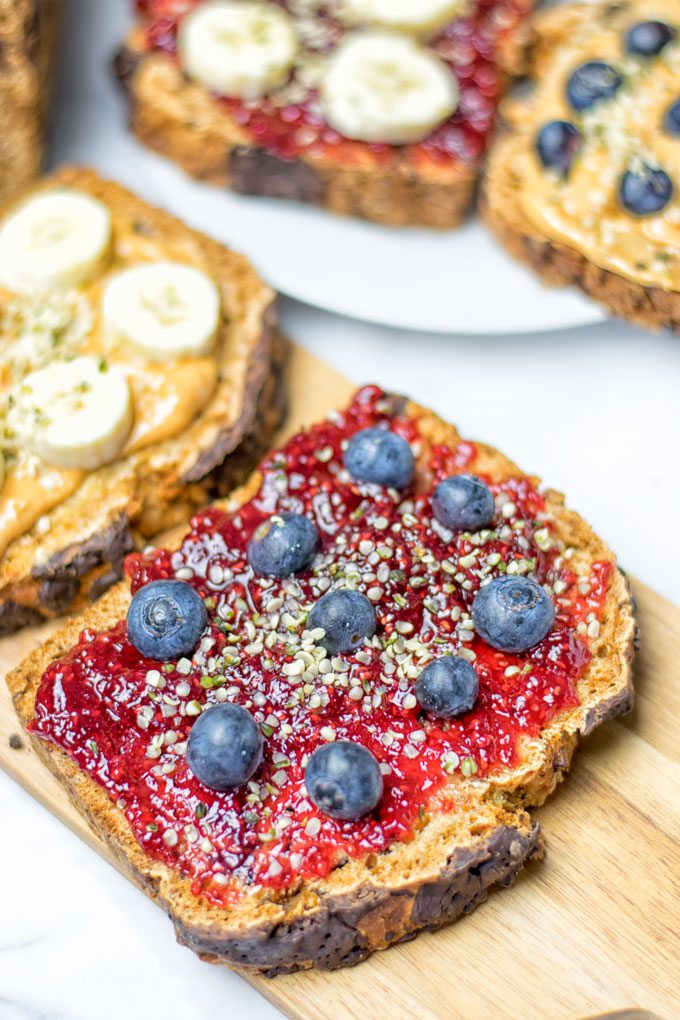 A slice of the Chocolate Chip Zucchini Bread with jam and blueberries.