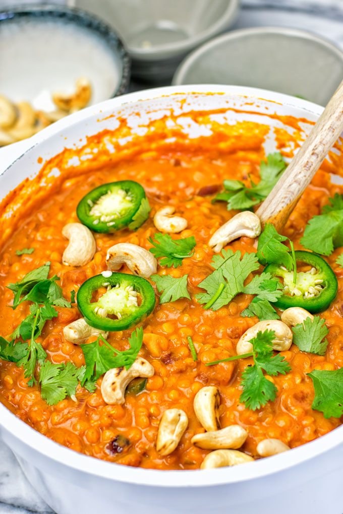 One Pot Red Lentil Dal garnished with fresh chili and toasted cashew nuts.