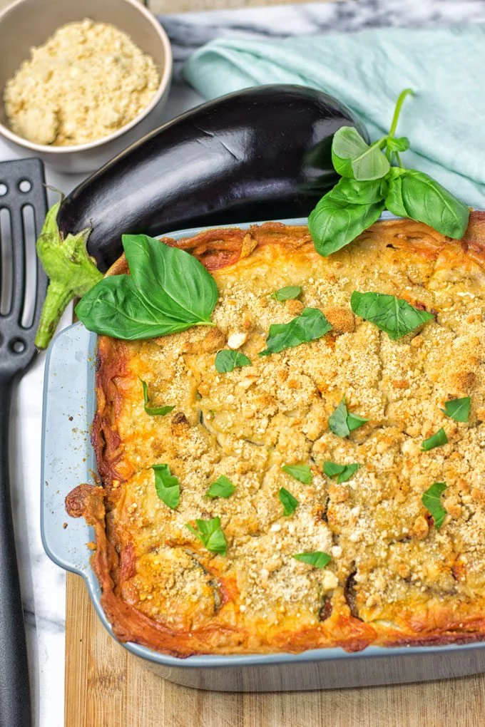 Garnishing the Eggplant Parmesan Zucchini Casserole with fresh basil.