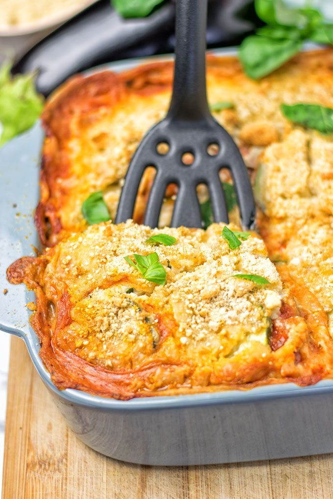 Lifting a portion of the Eggplant Parmesan Zucchini Casserole out of the dish.