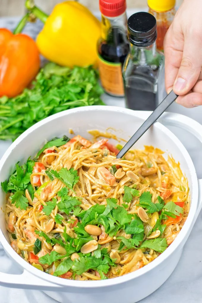 Lifting the Pad Thai Noodles with a fork out of the pot.