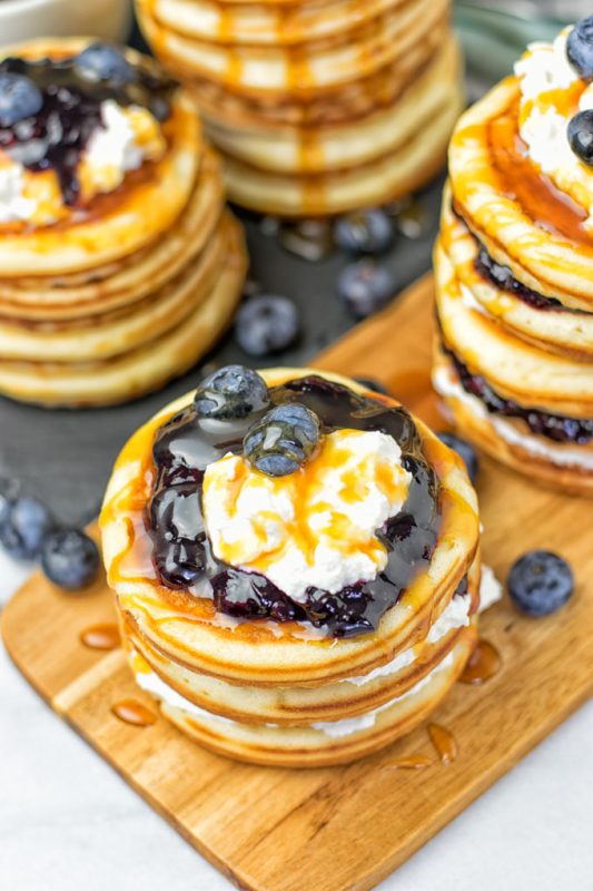 Vegan Ricotta Blueberry Pancakes stacks on a wooden board.