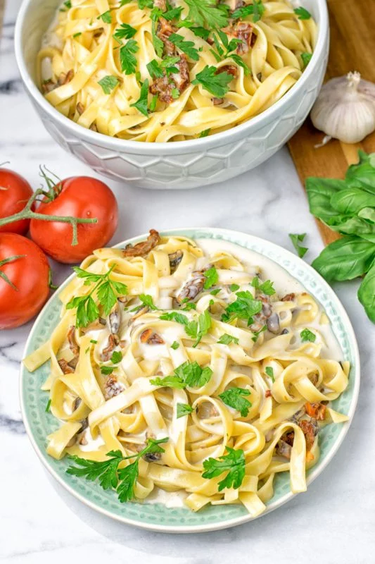 A portion of pasta with Roasted Garlic Carbonara Sauce on a plate.