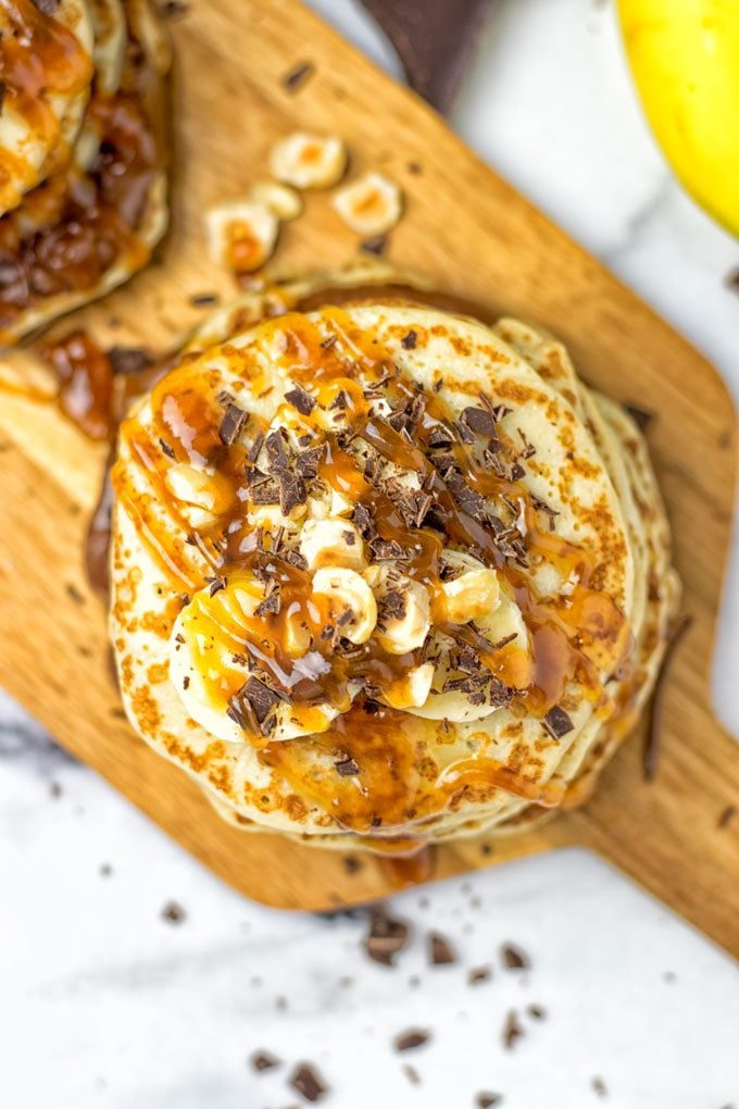 Two stacks of Vegan Caramel Nutella Pancakes on a serving board.