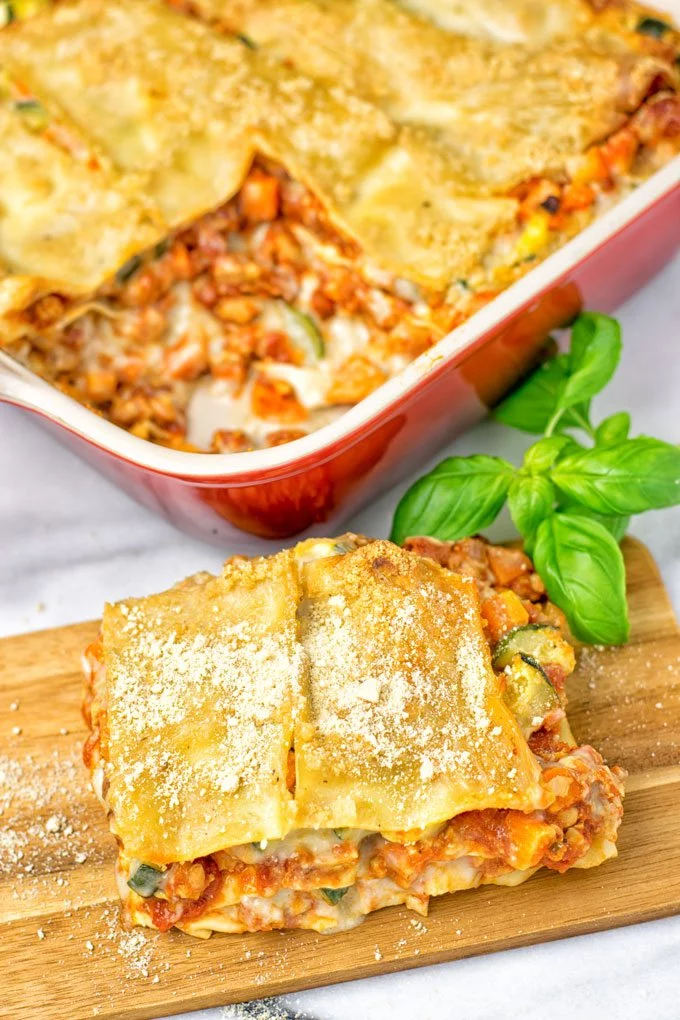 A piece of the Creamy Carbonara Vegetarian Lasagna with the casserole dish in the background. 