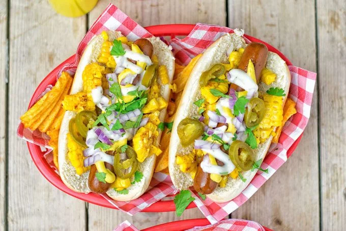 Top view on a basket with two Mexican Street Corn Hot Dogs