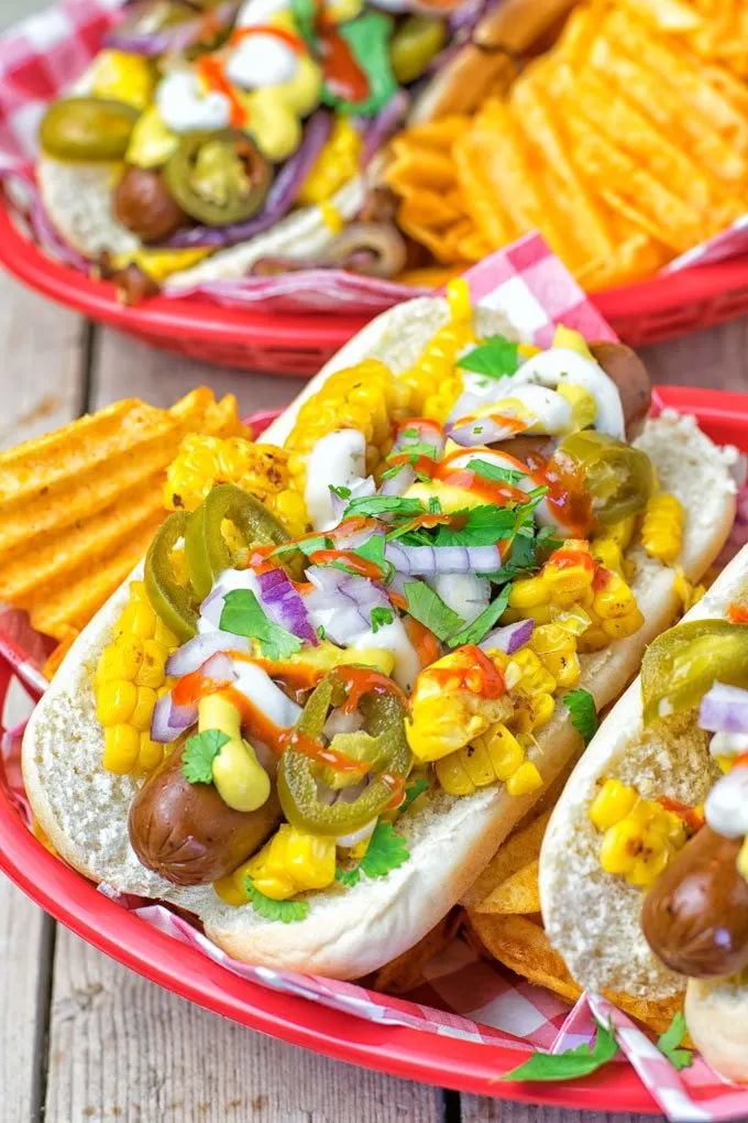 Mexican Street Corn Hot Dogs in red serving baskets.