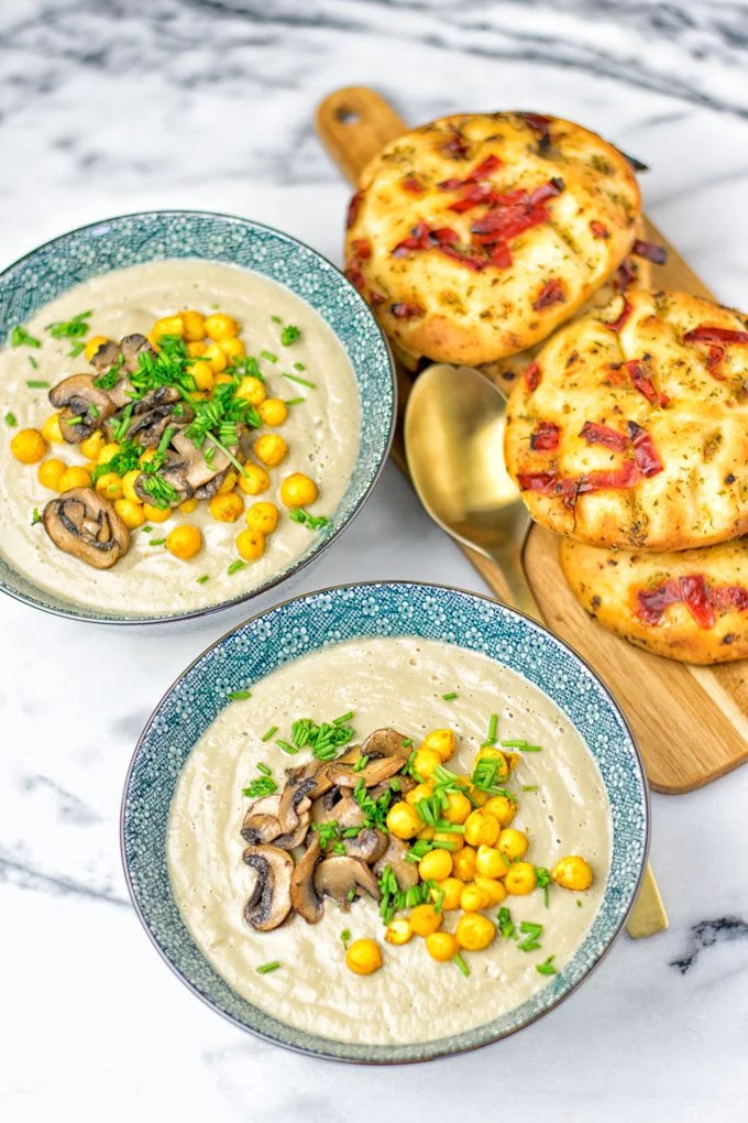 Roasted Chickpeas Cream of Mushroom Soup with small pieces of pizza bread in the background.