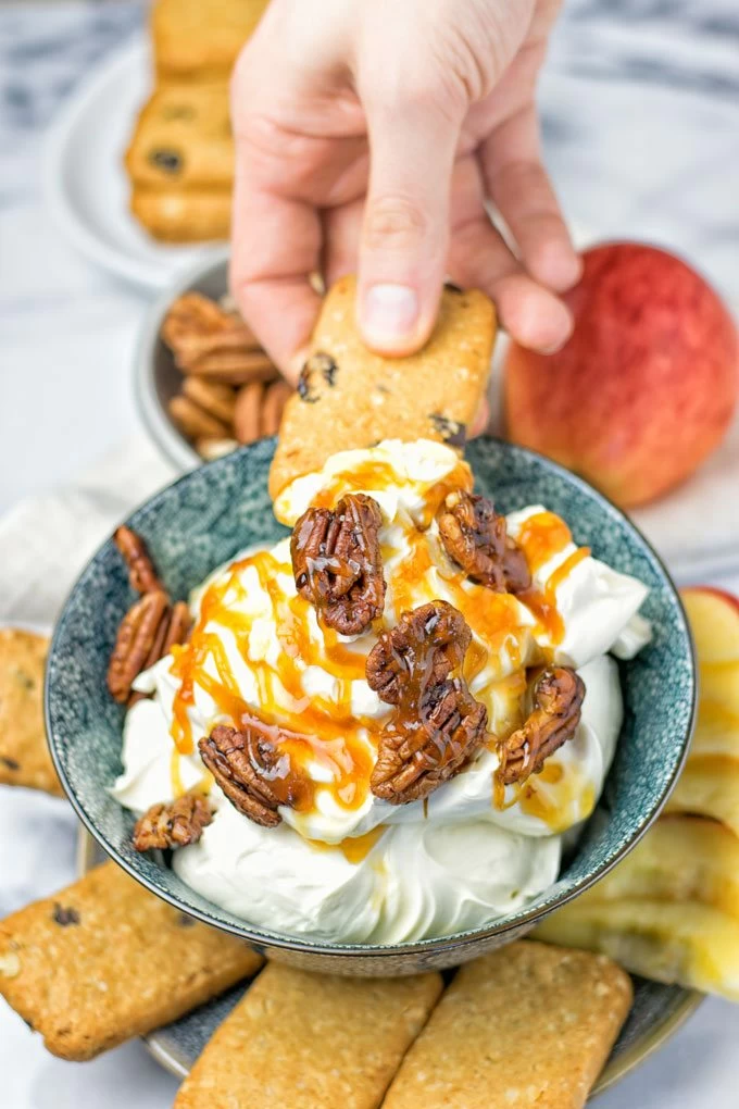 Dipping a cookie into the Salted Caramel Cream Cheese Dip.