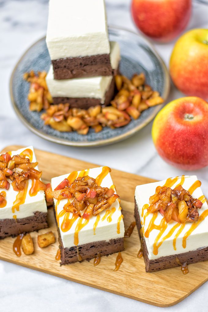 Three Cheesecake Brownies with Caramel Apples on a wooden board