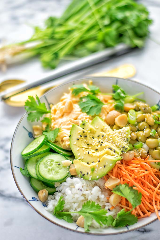 Easy and delicious: This Hawaiian Poke Bowl is naturally vegan, gluten free. Made with sushi rice, an amazing white cabbage mix with creamy sriracha sauce and edamame for protein richness. You can add options like shredded carrots, seaweed flakes, and more to build your dream bowl. Try it now and enjoy for lunch, dinner, meal prep! #vegan #glutenfree #vegetarian #dairyfree #contentednesscooking #dinner #lunch #pokebowl #hawaiianfood #easyfood #mealprep #budgetmeals #worklunchideas #bowlrecipes