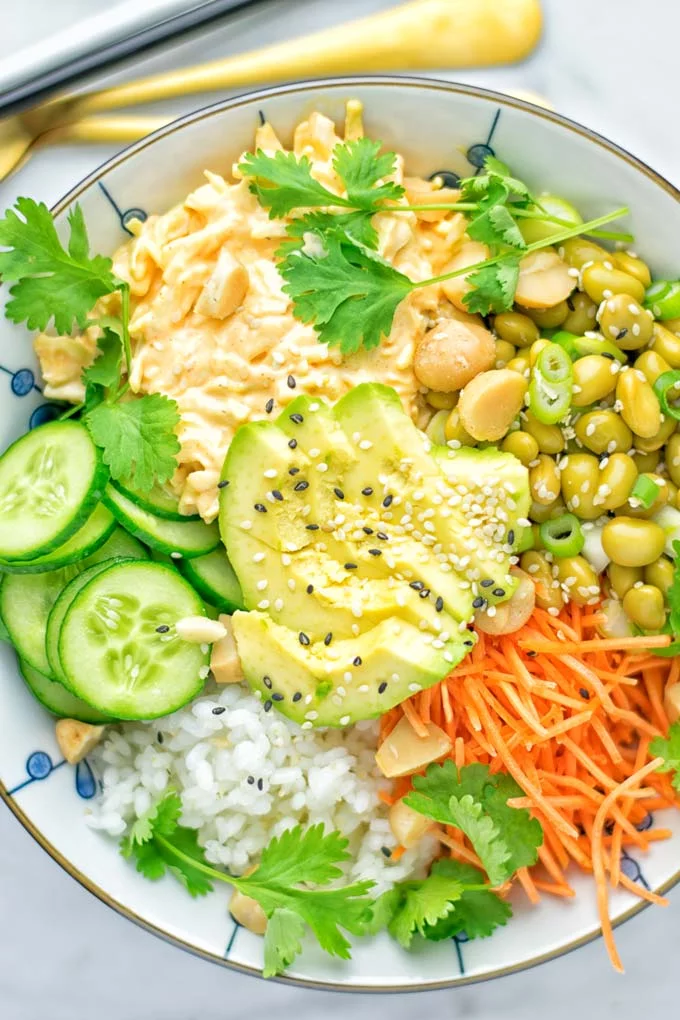 Easy and delicious: This Hawaiian Poke Bowl is naturally vegan, gluten free. Made with sushi rice, an amazing white cabbage mix with creamy sriracha sauce and edamame for protein richness. You can add options like shredded carrots, seaweed flakes, and more to build your dream bowl. Try it now and enjoy for lunch, dinner, meal prep! #vegan #glutenfree #vegetarian #dairyfree #contentednesscooking #dinner #lunch #pokebowl #hawaiianfood #easyfood #mealprep #budgetmeals #worklunchideas #bowlrecipes